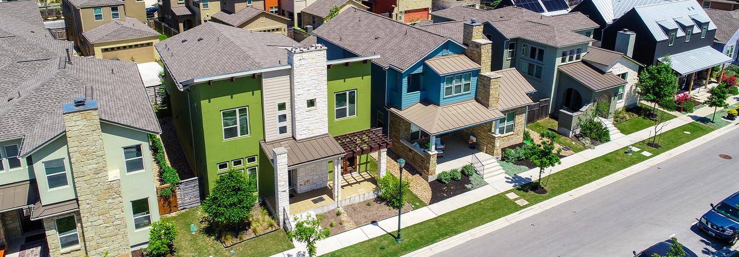 Green and blue and colorful houses facade Aerial drone view of suburb neighborhood in East Austin community houses and homes - Mueller Suburb Solar Panel Rooftops and Modern Austin Living